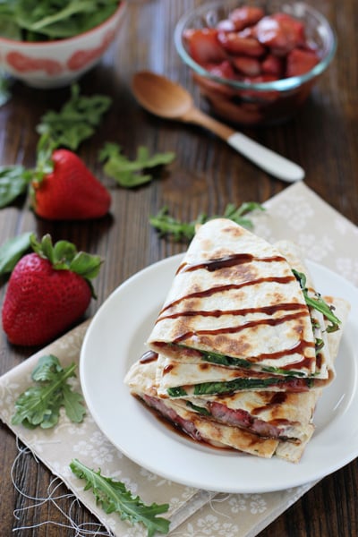 Cut triangles of Brie Quesadillas stacked on a plate.