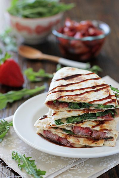 Several Roasted Strawberry Quesadillas stacked on a white plate.