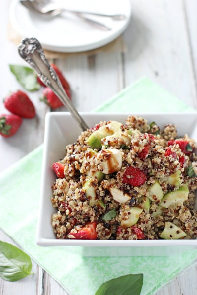 Strawberry Quinoa Salad in a white dish with a serving spoon.