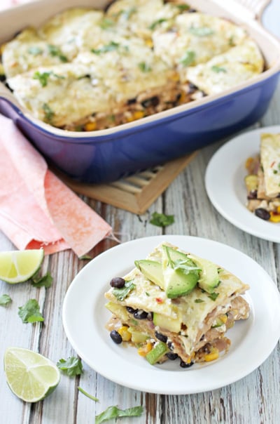 Two pieces on Vegetarian Enchilada Casserole on white plates.