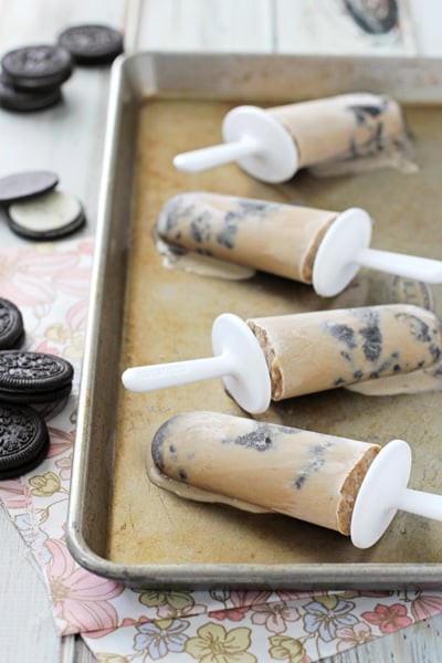 Four melty Coffee Popsicles on a baking sheet.