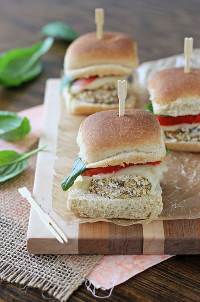 Three Crispy Eggplant Sliders on a wood cutting board.