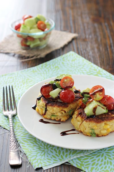 A white plate with two Easy Corn Fritters with a fork to the side.