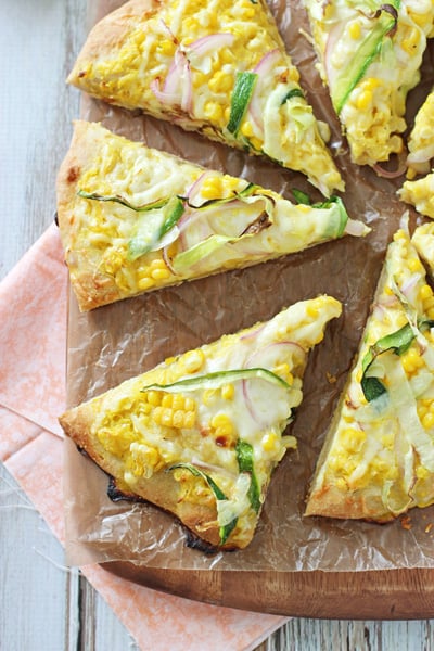 Several slices of Corn Pizza on a pizza peel.