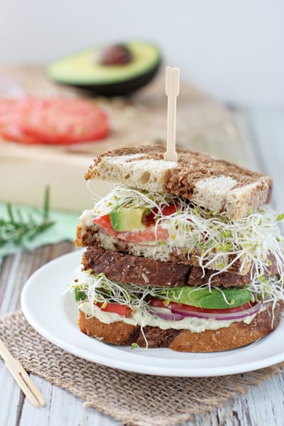 White Bean Sandwich Spread on an assembled sandwich stacked on a white plate.