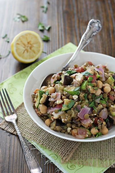 A white bowl with Mediterranean Chickpea Salad with a spoon in the dish.