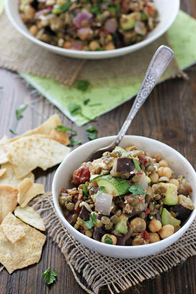 A small white bowl with Mediterranean Lentil Salad with a fork in the dish. 