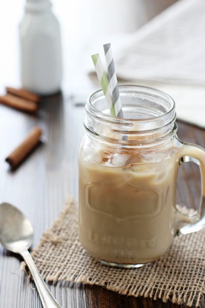 A glass mug filled with Honey Cinnamon Iced Latte and two straws.