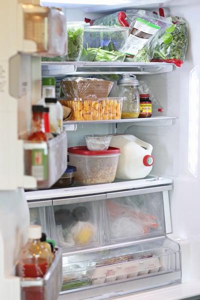 An open fridge stocked with lots of groceries.
