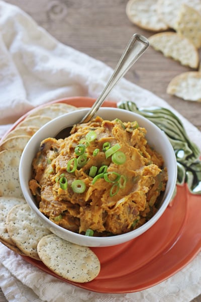 A serving platter filled with Savory Pumpkin Dip and crackers.