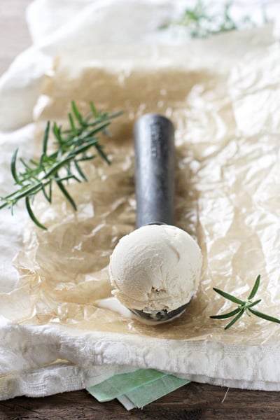 A scoop of Rosemary Ice Cream on a metal ice cream scoop.