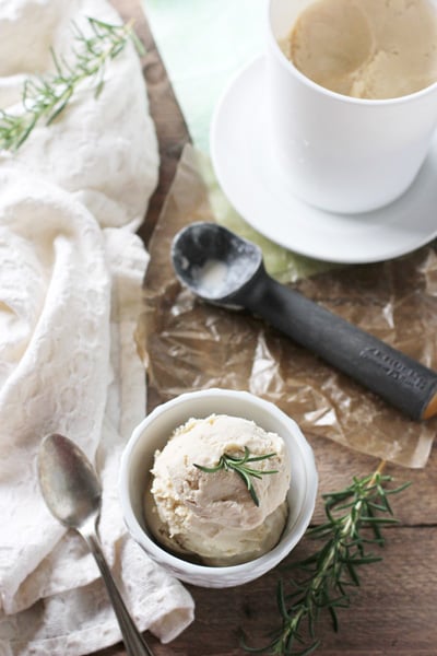 Homemade Rosemary Ice Cream in a white bowl with a pint to the side.