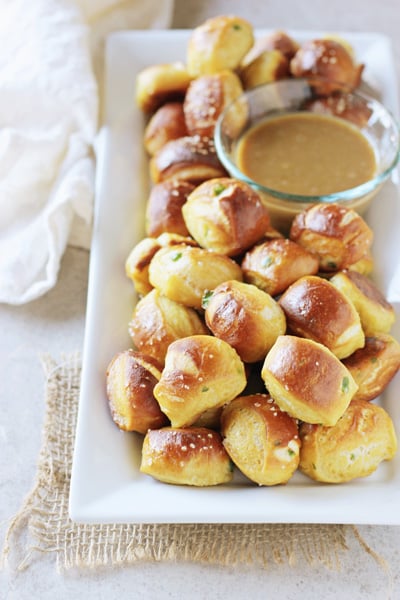 A white serving platter filled with Homemade Cheese Pretzels.
