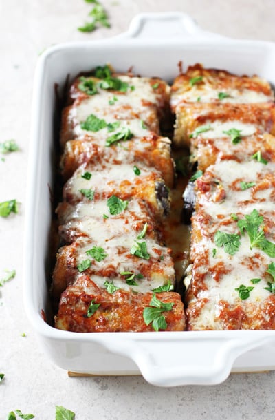 A white baking dish filled with Baked Eggplant Rollatini.