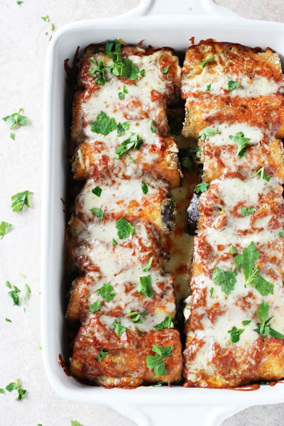 A white baking dish filled with Healthy Eggplant Rollatini.