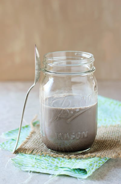 A ball jar filled with DIY Chocolate Syrup mixed with milk.