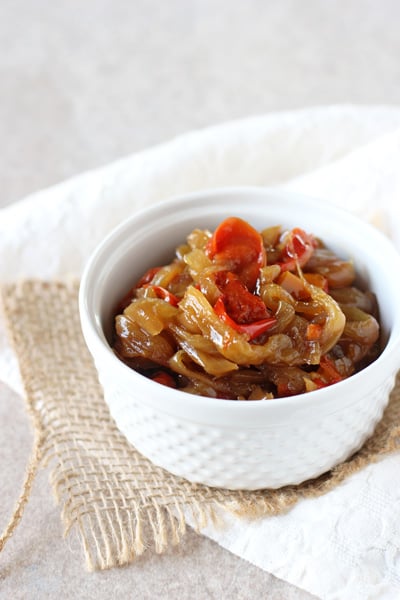 A white ramekin filled with Slow Cooker Caramelized Onions and Peppers.