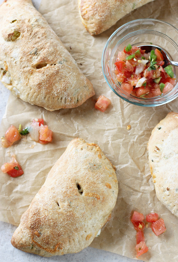 Four individual Breakfast Calzones on parchment paper.