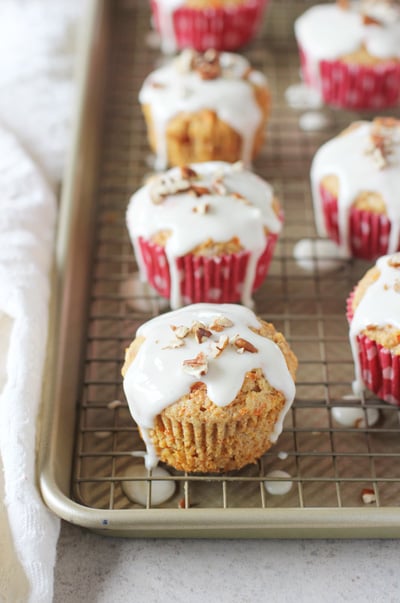 Several Healthy Carrot Cake Muffins set on a wire rack.