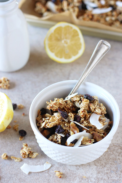 Lemon Blueberry Granola in a white bowl with lemon halves to the side.