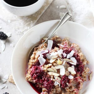 Recipe for creamy blackberry coconut bulgur breakfast bowl. With whole grain bulgur as the base and topped with a blackberry sauce, coconut and nuts!