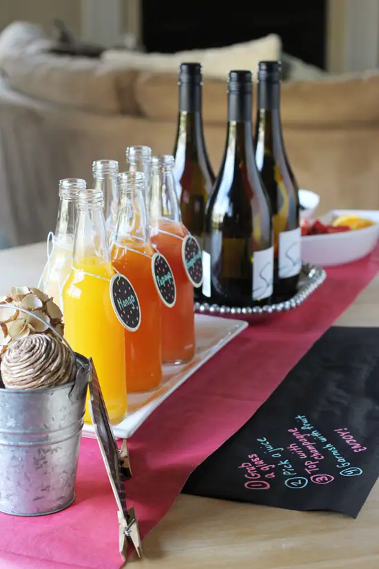 A DIY Mimosa Bar set up on a wooden table.