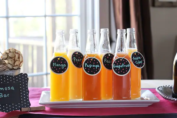 Different juices in glass bottles as part of a DIY Mimosa Bar.
