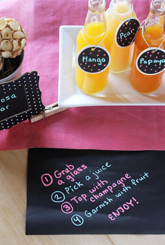 A DIY Mimosa Bar with instructions written on chalkboard paper.