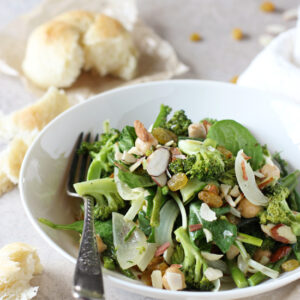 Recipe for a simple roasted spring veggie salad. Filled with asparagus and broccoli and a creamy tahini dressing. With golden raisins and sliced almonds!