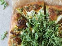 Recipe for arugula pesto pizza. With herbed ricotta, walnuts and lemon zest! Fresh, herby and cheesy!