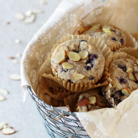 Recipe for blueberry almond whole grain muffins. With whole wheat flour, oat bran and sweetened with honey and maple syrup. Packed with blueberries!