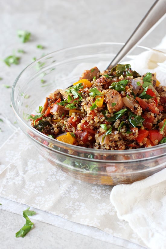 A glass mixing bowl filled with Cajun Quinoa.