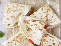 Recipe for weeknight sweet and salty thai vegetable quesadillas. Packed with red pepper, zucchini, cabbage and pineapple! Serve with a homemade cilantro pesto!