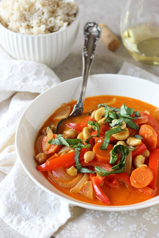 A white bowl filled with Vegetarian Thai Red Curry with a spoon in the dish.