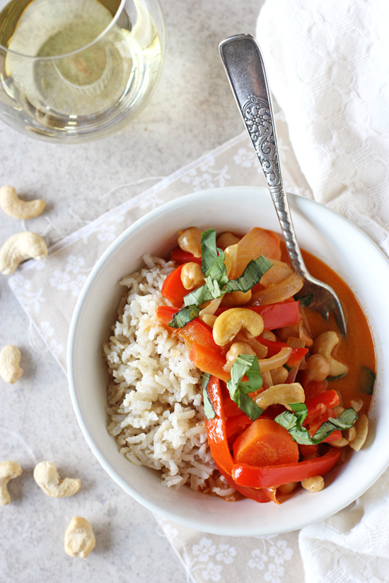 A white bowl filled with Vegan Thai Red Curry and brown rice.
