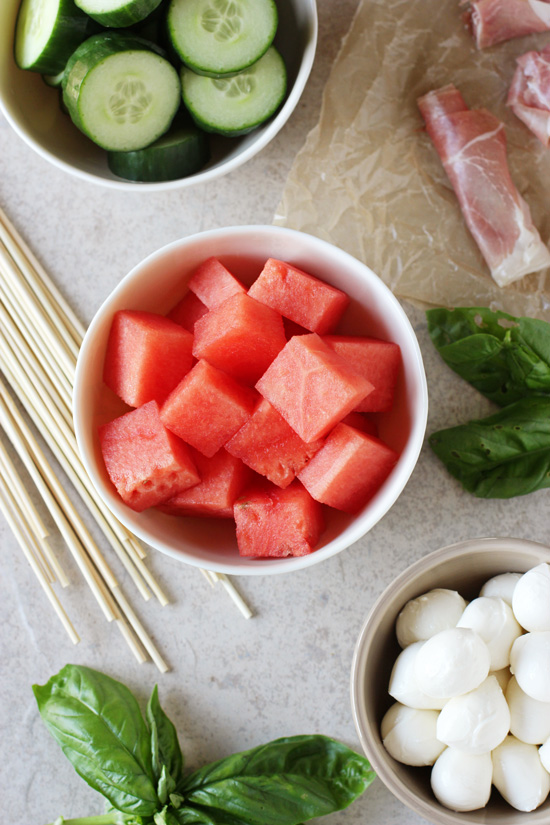 Small bowls filled with the components for Watermelon Mozzarella Skewers.