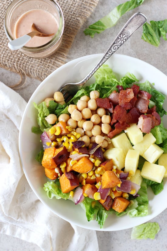 A white bowl filled with BBQ Sweet Potato Salad with a fork in the dish.