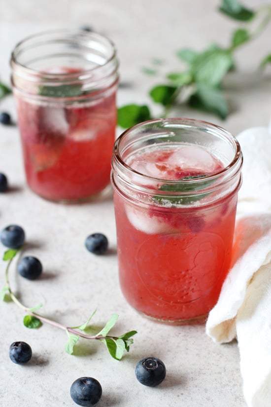 Two ball jars filled with Blueberry Mint Sparkling Lemonade.