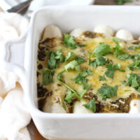 Recipe for fresh corn, zucchini and black bean enchiladas. With a creamy filling from a sauce made of fresh corn kernels! Topped with salsa verde and cheese!