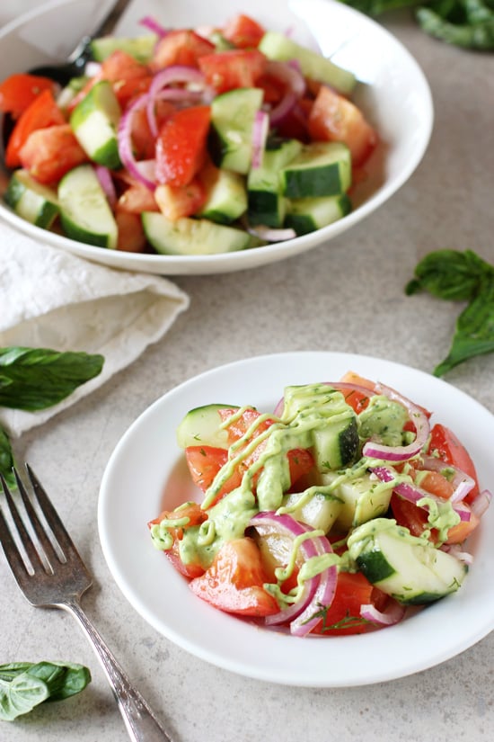 A small plate and serving bowl filled with Green Goddess Cucumber Salad.