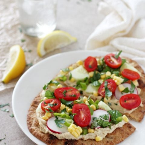 Recipe for 30-minute easy summer garden veggie flatbreads. With a crispy naan base, hummus and plenty of fresh veggies and herbs!