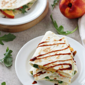 Recipe for quick & easy peach and white bean quesadillas. With a basil-packed white bean spread, fresh peaches, arugula and balsamic glaze!