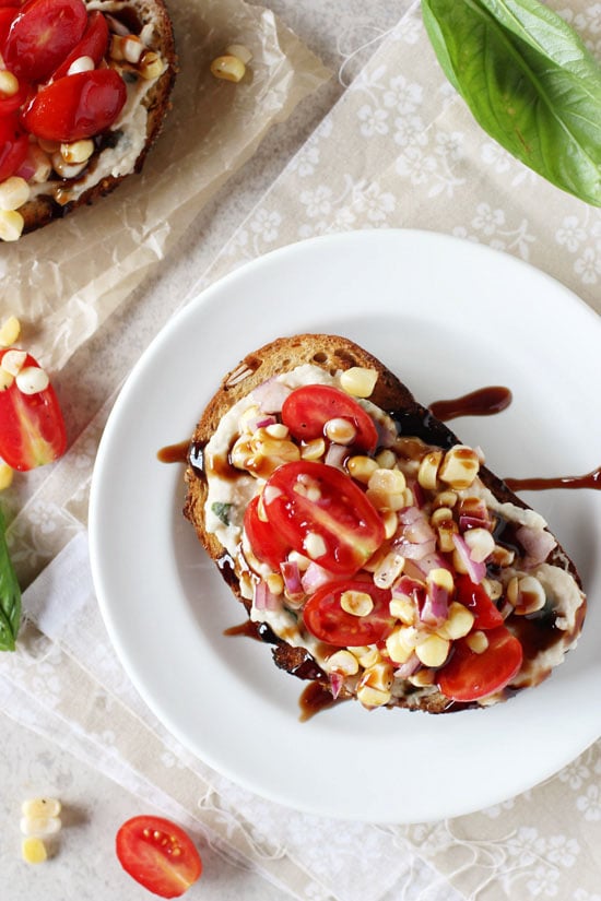 A Tomato White Bean Sandwich on a white plate drizzled with balsamic glaze.