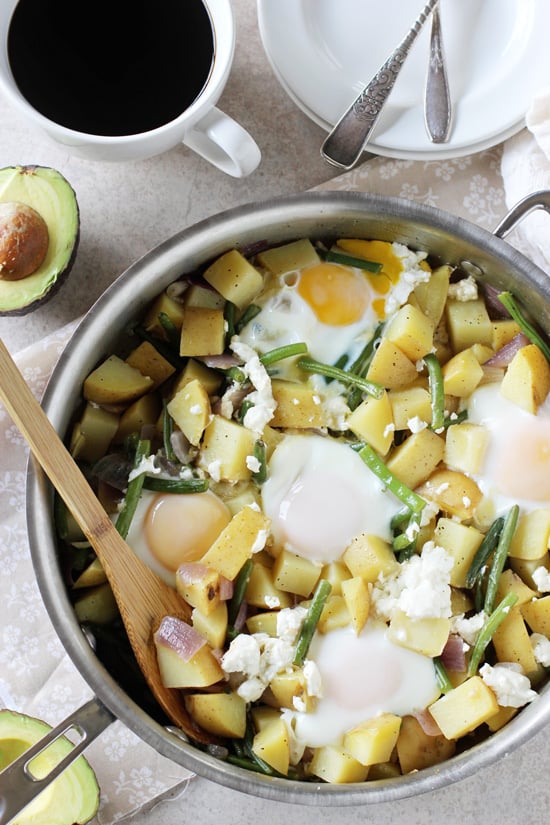 A stainless skillet filled with Potato, Green Bean and Goat Cheese Breakfast. 