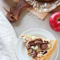 Recipe for sweet and savory apple bratwurst pizza. With sliced apples, sausage, red onion and goat cheese! An easy weeknight meal!
