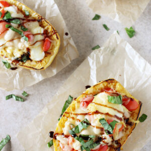Recipe for caprese stuffed spaghetti squash. Spaghetti squash infused with basil and garlic, then filled with cherry tomatoes and mozzarella! Finished with balsamic glaze!