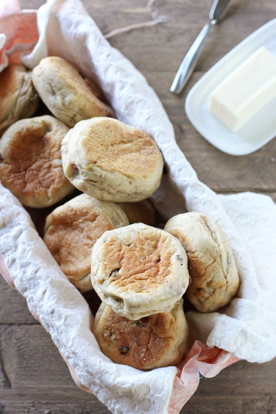 Cranberry English Muffins in a bread basket with butter to the side.