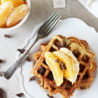 Recipe for orange and dark chocolate waffles. Made with white whole wheat flour and coconut oil! Filled with orange zest and chopped dark chocolate!