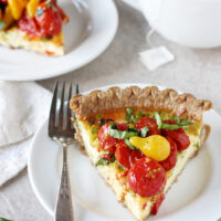 Recipe for tomato and goat cheese quiche. A simple, make ahead dish filled with green onions and goat cheese! And topped with plenty of roasted tomatoes!