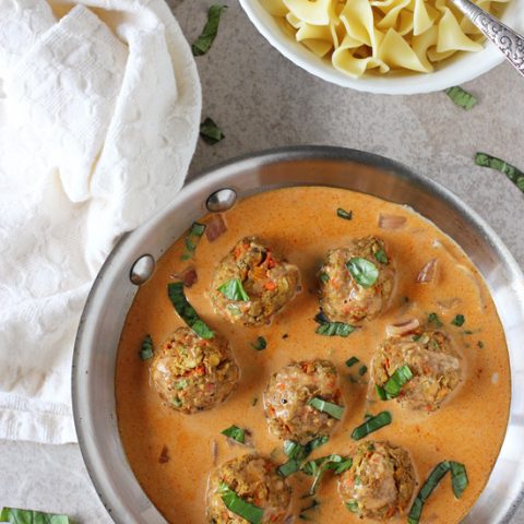 Recipe for thai red curry baked vegetable meatballs. Flavorful veggie and chickpea meatballs served in a creamy thai red curry sauce! Finished with fresh basil!